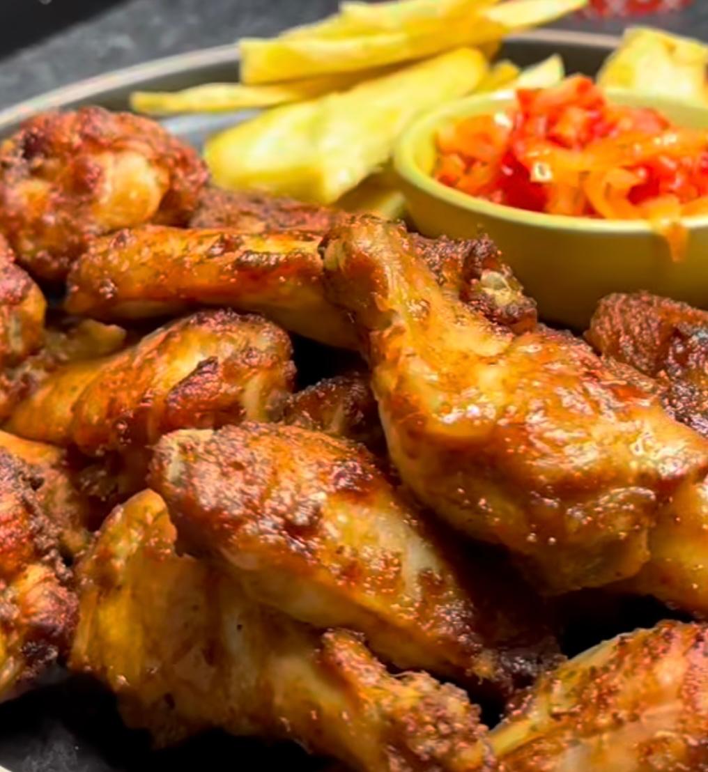 Grilled chicken served with golden fries, fresh plantain slices, and pepper relish