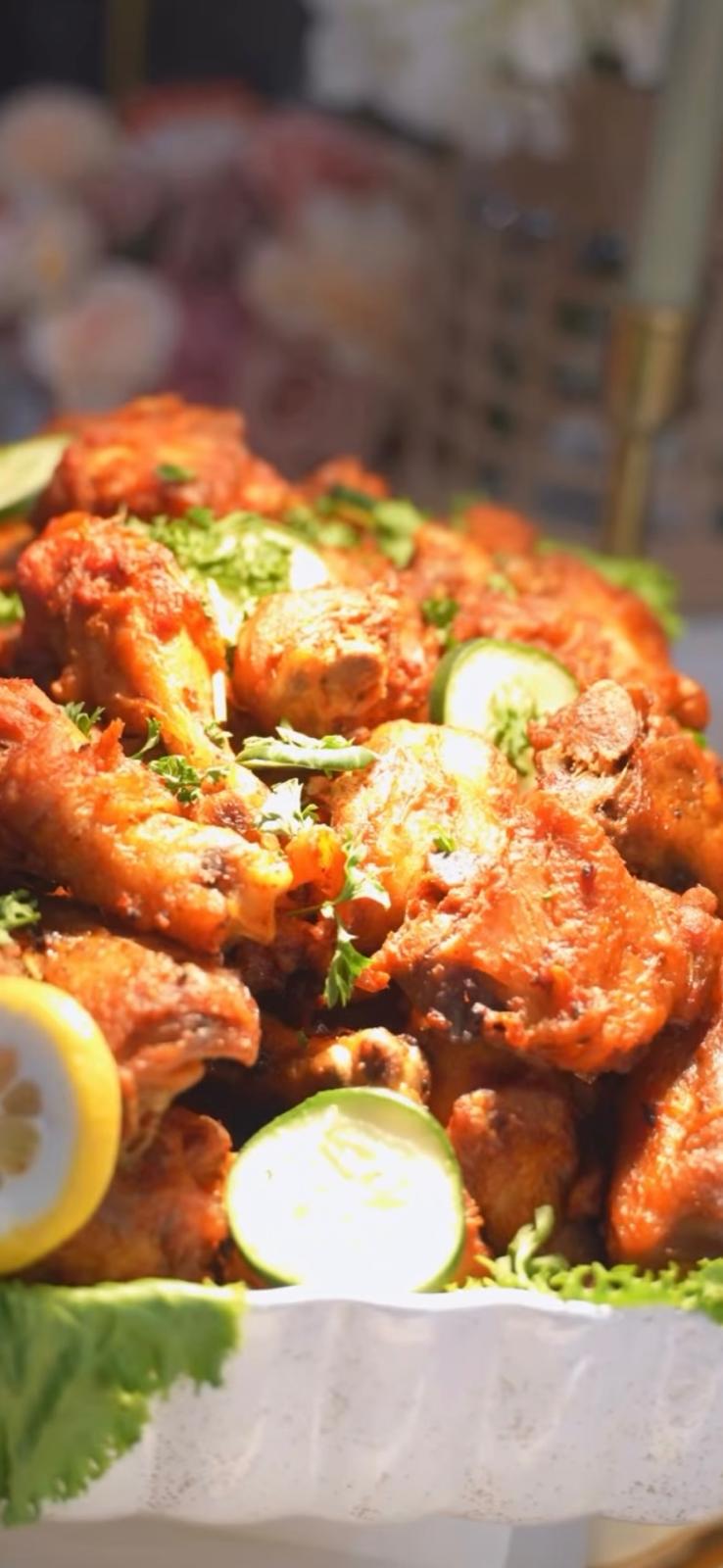 Crispy seasoned wings garnished with lemon, cucumber and fresh herbs
